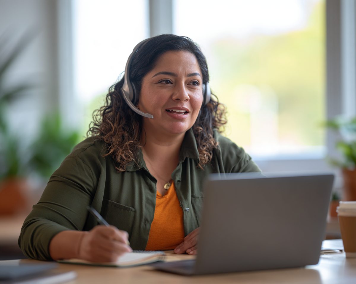 Energy Academy team member answering a question on a headset at her laptop