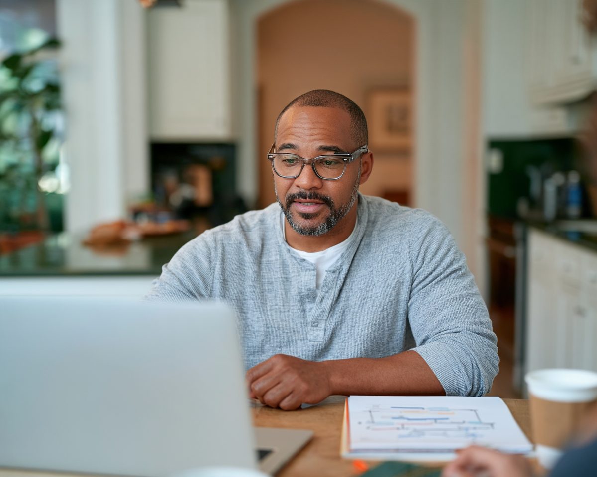 Career changer working through an online renewable energy lesson at a kitchen table