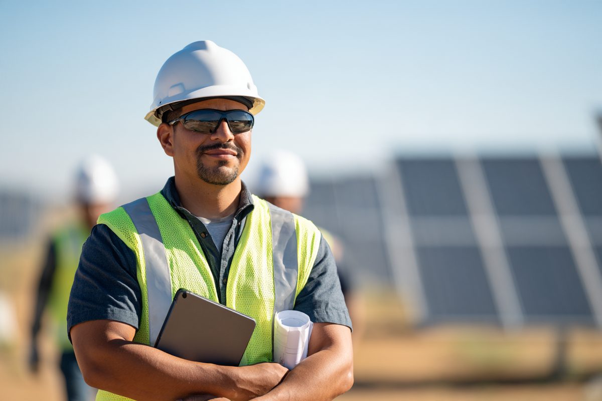 Engineer in a hard hat reviewing a set of design drawings